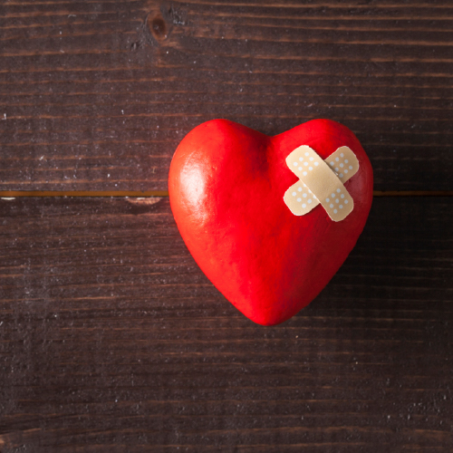 A red heart with a bandage on it